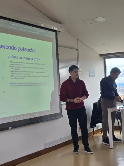 Andrés Yañez durante la presentación de su tesis, frente a una diapositiva